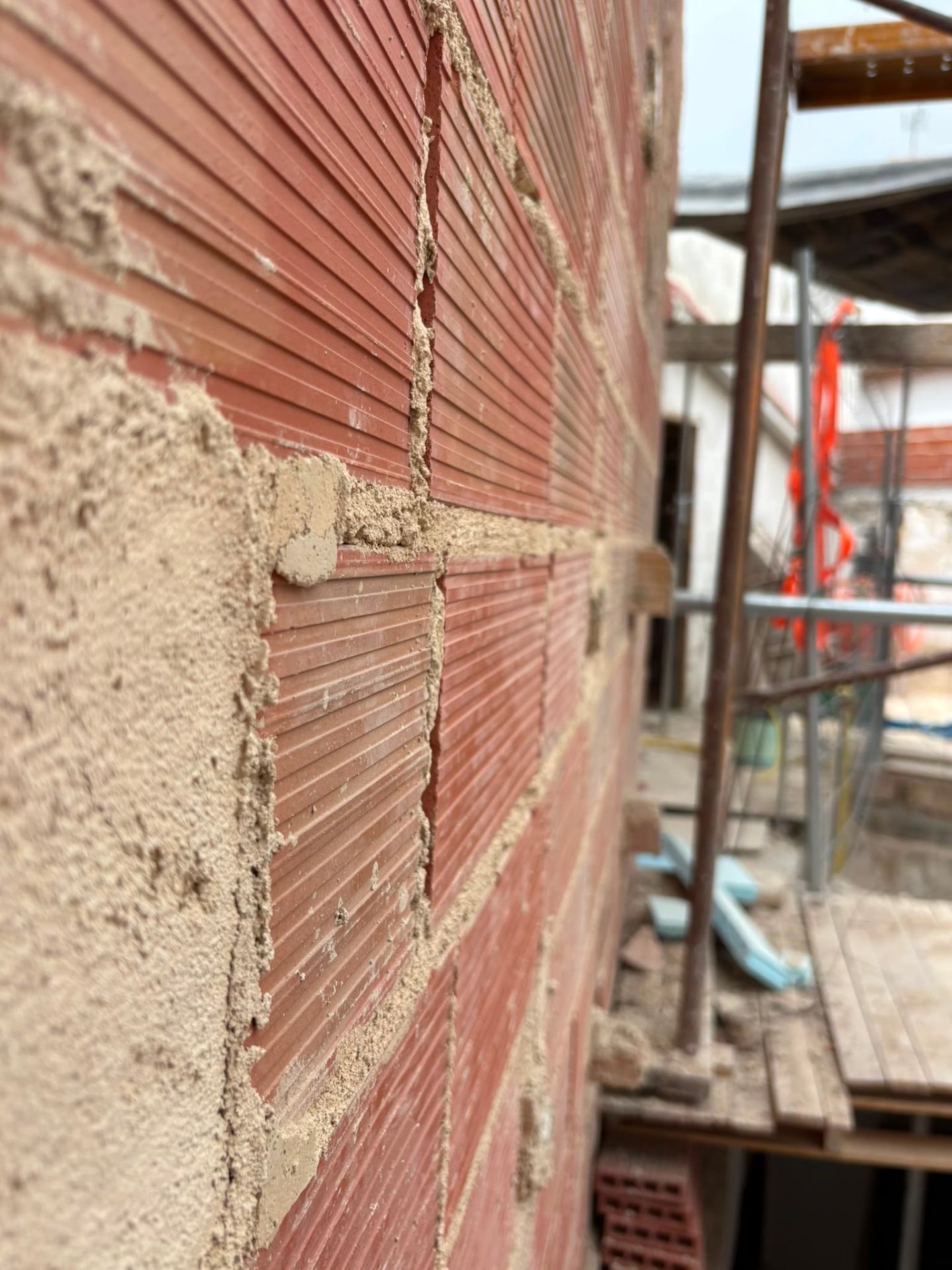 Muros nuevos de Purissima House levantados con ladrillo cerámico visto y mortero de rejuntado, durante la rehabilitación.